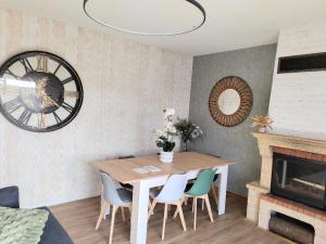 a dining room with a table and chairs and a clock at Bel Horizon in Saint-Jean-Froidmentel +11 photos