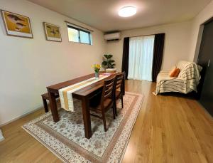 a living room with a dining room table and a couch at 藍遊び in Fukuoka