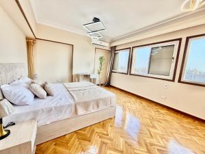 a bedroom with a large bed and large windows at Golden mile - Downtown Cairo in Cairo