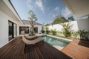 a wooden deck with a bench and a swimming pool at Kubu Tebo Villa Uluwatu in Uluwatu