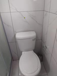 un aseo blanco en un baño de azulejos blancos en Vumasky 2, en Ladysmith