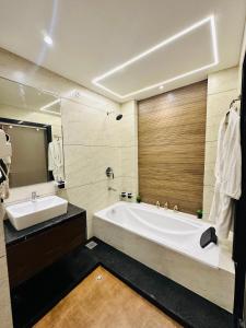 a bathroom with a large tub and a sink at Hotel Casa Inn in Indore