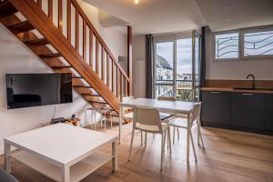 a kitchen and living room with a table and chairs at Les balcons de la Thalasso in Roscoff