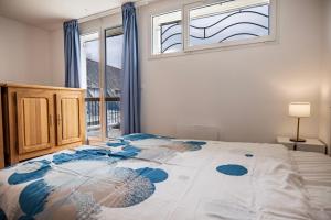 a bedroom with a large bed with a window at Les balcons de la Thalasso in Roscoff