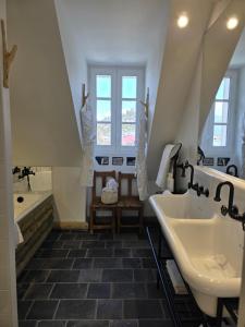 ムジェーヴにあるChalet Boréal Centre Megèveの洗面台2つとバスタブ付きのバスルーム