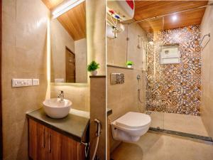 a bathroom with a toilet and a sink and a shower at Lush View 2BHK Apartments in Candolim in Candolim