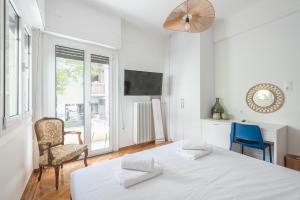 a bedroom with a bed and a chair and a window at Zen Elements, Cozy Guesthouse in City Center in Athens