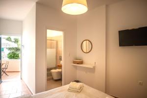 a bedroom with a bed and a television and a bathroom at Twin House Spetses in Spetses +55 photos