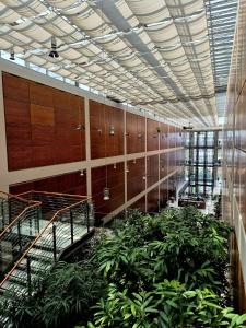 DoubleTree by Hilton Turin Lingotto في تورينو: ممر به نباتات وخزانات في مبنى