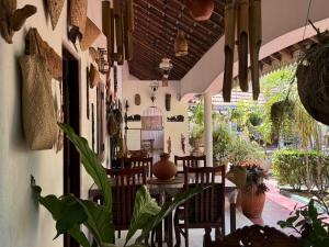 a dining room with a table and chairs and plants at Embiente Guest House in Negombo