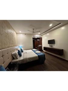 a hotel room with a bed and a flat screen tv at Hotel The Westinn in Varanasi +7 photos