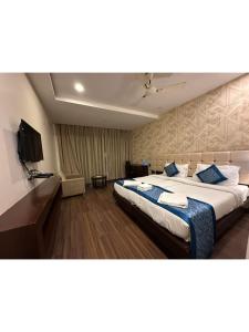 a hotel room with a large bed with blue pillows at Hotel The Westinn in Varanasi