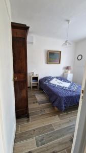 a bedroom with a bed and a wooden floor at Chambre cosy avec salle-de-bain privative in Béziers