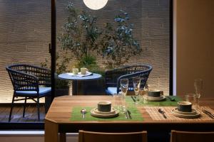 a table with chairs and a table with plates and glasses at Minn Gion Sanjo in Kyoto