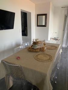 une table à manger avec des chaises et une télévision dans l'établissement Appartement T2 rez de villa, à Santa-Reparata-di-Balagna