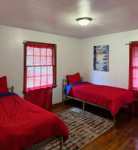 ディケーターにあるHome away from home!の赤いシーツが備わるドミトリールームのベッド2台