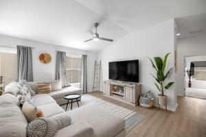 a living room with a couch and a flat screen tv at Cozy 2BR With Golfcart 5 Mins to Eastport Sq in Wildwood
