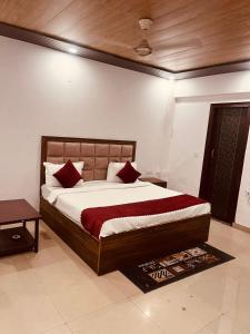 ein Schlafzimmer mit einem großen Bett mit roten Kissen in der Unterkunft Hotel Cladis - Noida Sec 19 in Noida + 6 Fotos
