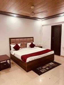 ein Schlafzimmer mit einem großen Bett mit roten Kissen in der Unterkunft Hotel Cladis - Noida Sec 19 in Noida