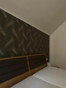 a bedroom with a bed and a black and brown wall at Casa del Mondo 3 in Sankt Aldegund