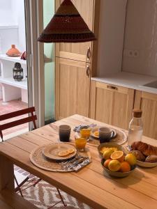 una mesa de madera con productos para el desayuno en Casa Dar Alma, en Vila Real de Santo António 47 fotos más
