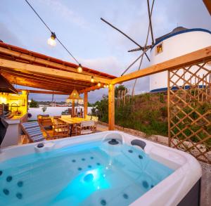a hot tub on a patio with a windmill at The Indigo Windmill Retreat in Lourinhã