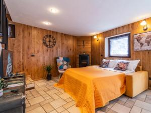 a bedroom with a bed in a room with wooden walls at LA CASA DI PIETRA - Relax Home a 10' da Aosta in Roisan