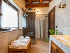 a bathroom with a sink and a shower with towels at LA CASA DI PIETRA - Relax Home a 10' da Aosta in Roisan