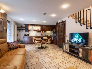 a living room with a couch and a tv and a kitchen at LA CASA DI PIETRA - Relax Home a 10' da Aosta in Roisan