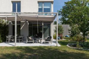 eine Terrasse mit Tisch und Stühlen in einem Hof in der Unterkunft Warsaw Concierge Konstancin Garden Sauna Yoga in Konstancin-Jeziorna