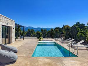 a swimming pool on a patio with chairs at PanStel - Villa Solene with private pool in Ayiá