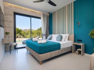a bedroom with a large bed with a blue wall at PanStel - Villa Solene with private pool in Ayiá +66 photos