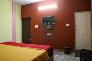 a room with a bed and a tv on a wall at Lakeside Room stay in Yelagiri +16 photos