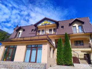 a large house with a roof at Prestige Accommodation & Wellness in Predeal