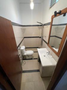 a bathroom with a sink and a toilet and a mirror at Yu BAMBOOS AIRPORT TRANSIT HOTEL in Seeduwa +12 photos