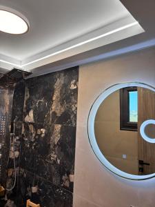 a bathroom with a round mirror on a wall at Cretan stars villas in Limín Khersonísou