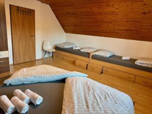 two beds in a room with wooden ceilings at Chata U Elka in Týn nad Vltavou