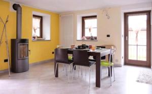 a dining room with a table and chairs and a stove at Casa Valtournenche in Valtournenche