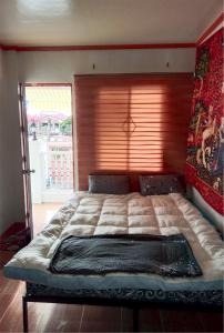 un letto grande in una camera da letto con finestra di Your Little Resort, calm, secure a Manila