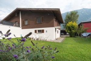 a house with chairs and a table in a yard at Haus Nussbaumweg 6 in Giswil