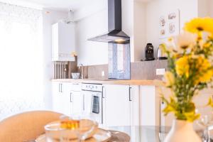 une cuisine avec une table en verre et un vase de fleurs dans l'établissement Appartement Cocoon Chalons Centre, à Châlons-en-Champagne 33 autres photos