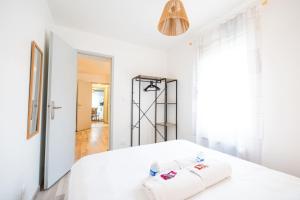 une chambre blanche avec un lit et un miroir dans l'établissement Appartement Cocoon Chalons Centre, à Châlons-en-Champagne