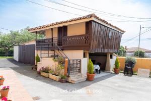 a house with a balcony on top of it at Villa Marina - Las Casas del Oso in Granda