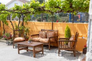 a patio with a couch and chairs and a table at Villa Marina - Las Casas del Oso in Granda