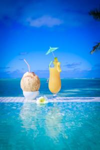 
two orange and yellow umbrellas sitting on top of a blue ocean at Crystal Blue Lagoon Villas in Rarotonga
