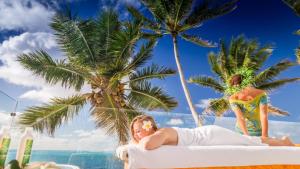
a woman laying on top of a beach next to palm trees at Crystal Blue Lagoon Villas in Rarotonga
