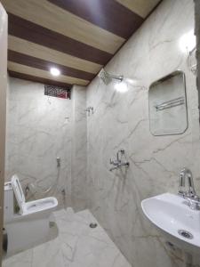 ein weißes Badezimmer mit Waschbecken und Toilette in der Unterkunft Heritage Kashi in Varanasi