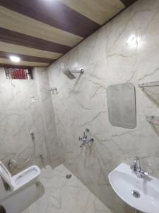 ein Badezimmer mit Waschbecken, Spiegel und Toilette in der Unterkunft Heritage Kashi in Varanasi