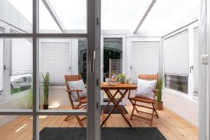 a conservatory with a table and chairs on a patio at Haus am Damm in Pinneberg