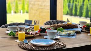 a table with plates of food and glasses of orange juice at Apartament Boosko Ciao! in Busko-Zdrój